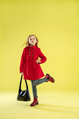 Image showing A full length portrait of a bright fashionable girl in a raincoat