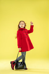 Image showing A full length portrait of a bright fashionable girl in a raincoat