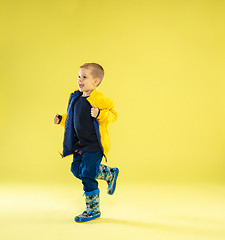 Image showing A full length portrait of a bright fashionable boy in a raincoat