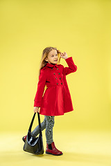 Image showing A full length portrait of a bright fashionable girl in a raincoat