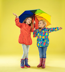 Image showing A full length portrait of a bright fashionable girls in a raincoat