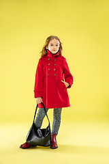 Image showing A full length portrait of a bright fashionable girl in a raincoat