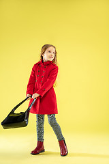 Image showing A full length portrait of a bright fashionable girl in a raincoat