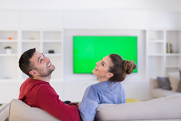 Image showing Young couple on the sofa watching television