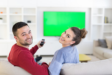 Image showing Young couple on the sofa watching television