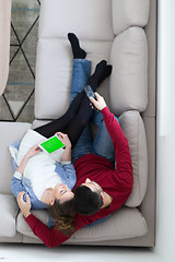 Image showing Young couple on the sofa watching television top view