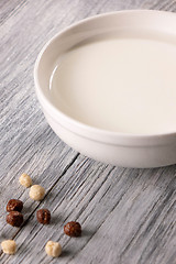 Image showing White plate of milk and different cereal balls on a gray wooden table. Breakfast cereals