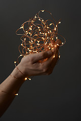 Image showing bright christmas lights in woman\'s hands