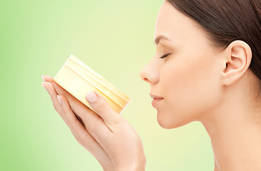 Image showing beautiful woman smelling moisturizing cream aroma