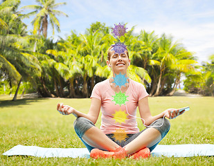 Image showing woman meditating in summer park with seven chakras