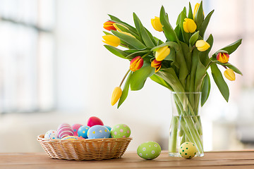 Image showing colored easter eggs in basket and flowers at home