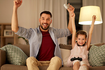 Image showing father and daughter playing video game at home