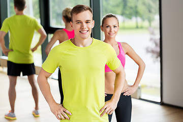 Image showing smiling man and woman exercising in gym