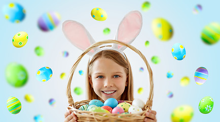 Image showing happy girl with colored easter eggs in basket