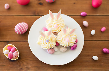 Image showing cupcakes with easter eggs and candies on table