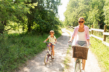 Image showing mother and daughter riding bikes in summer park