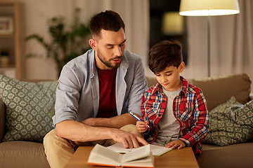 Image showing father and son doing homework together