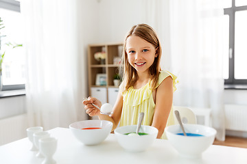 Image showing girl coloring easter eggs by liquid dye at home