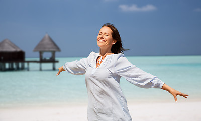 Image showing happy woman over beach and bungalow on background