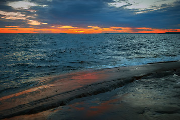 Image showing Orange Sunset Over a Stormy Lake 