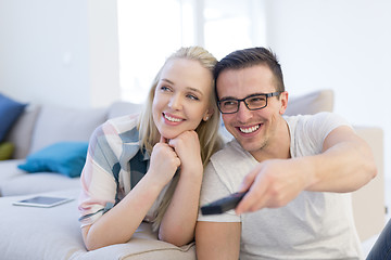 Image showing Young couple on the sofa watching television