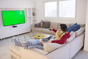 Image showing Young couple on the sofa watching television