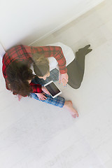 Image showing Young Couple using digital tablet on the floor