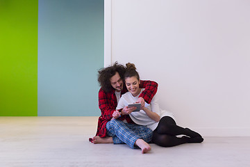 Image showing Young Couple using digital tablet on the floor