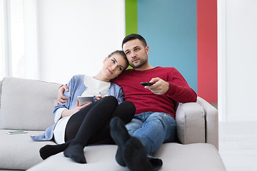 Image showing Young couple on the sofa watching television