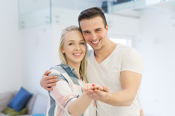 Image showing couple showing small red house in hands