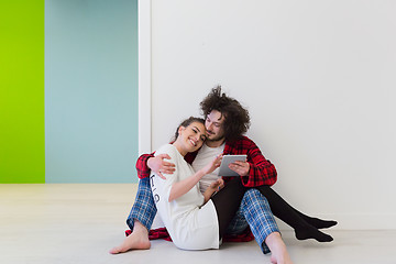 Image showing Young Couple using digital tablet on the floor