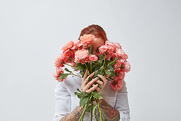 Image showing Congratulation bouquet of roses in the gerl\'s hands with a tattoo on a white background. Trend color of the year 2019 Living Coral Pantone.