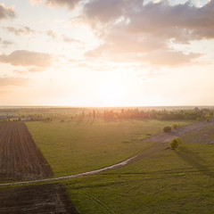 Image showing Aerial view from the drone, a bird\'s eye view of abstract geometric forms of abandoned runway, forests and agricultural fields in the summer evening at sunset.