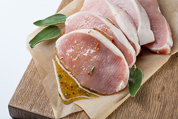 Image showing raw pork escalope with sause made of honey and herbs