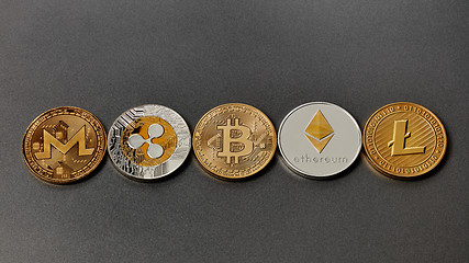 Image showing Five different coins of crypto-currencies presented in a row on a dark background. Virtual money concept. Top view