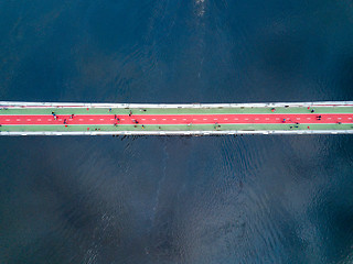 Image showing People are walking on the pedestrian bridge in Kiev on a spring day. View from above