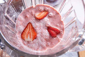 Image showing Freshly prepared strawberry smoothie in a blender bowl. Healthy food. Top view