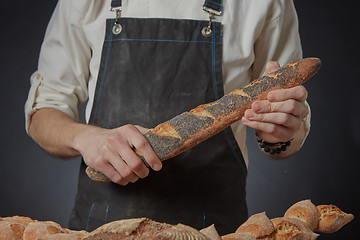 Image showing Men\'s hands hold a baguette