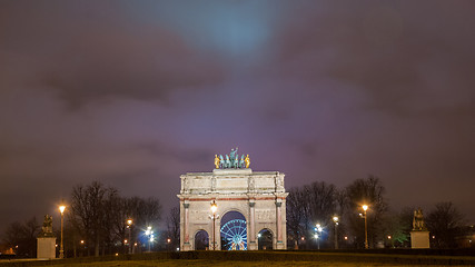 Image showing Paris, France - August 04, 2006: Night panorama of the Triumphal arch du Carrousel on the background of the Ferris wheel and luminous street lamps