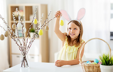 Image showing girl decorating willow by easter eggs at home