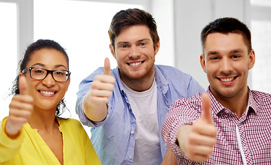 Image showing happy creative team showing thumbs up at office