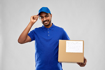 Image showing happy indian delivery man with parcel box in blue