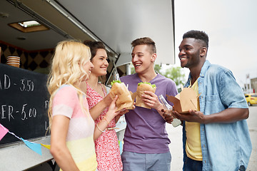 Image showing happy friends with drinks eating at food truck