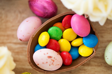 Image showing chocolate easter egg and candy drops on table