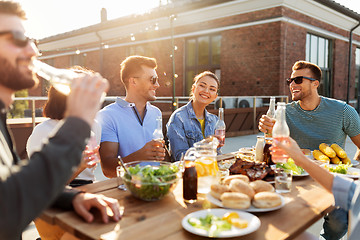 Image showing happy friends with drinks or bbq party on rooftop