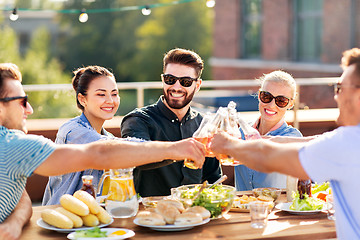 Image showing happy friends toasting drinks at rooftop party