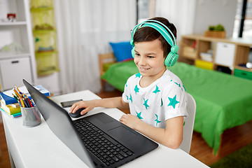 Image showing boy in headphones playing video game on laptop