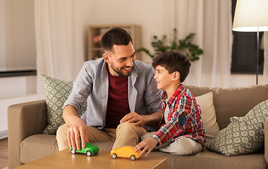 Image showing father and son playing with toy cars at home