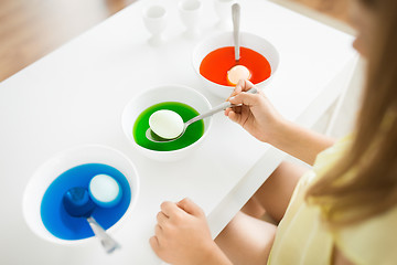 Image showing girl coloring easter eggs by liquid dye at home