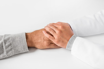 Image showing close up of doctor holding senior patient hand